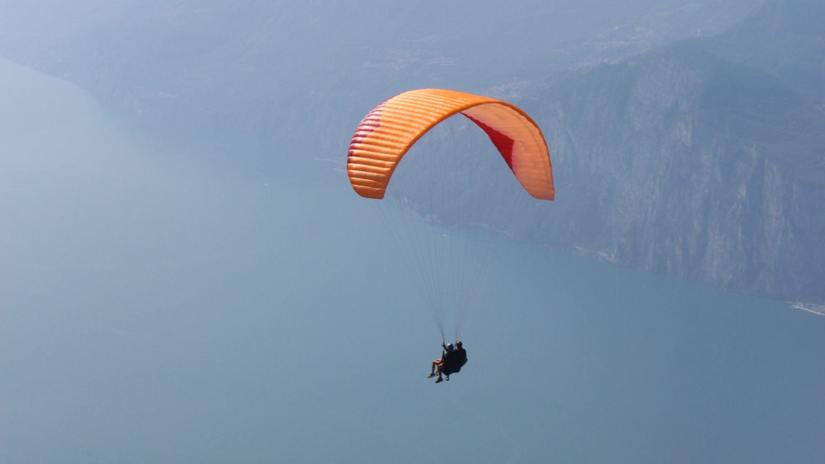 Gleitschirmflug über dem Gardasee mit Bergpanorama