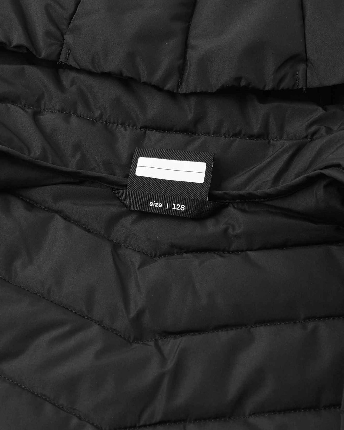 Chaqueta aislante ligera Reima Uumaja para niños, color negro – Detalle de la etiqueta con el nombre